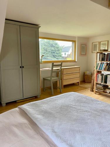a bedroom with a bed and a desk and a window at Cottage by the Jizera river in Nový Vestec