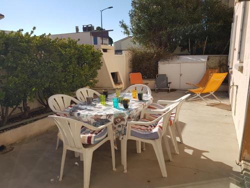 une table et des chaises assises sur une terrasse dans l'établissement Narbonne-Plage : Appartement T2 Climatisé, 35m², Pieds dans l'eau, 4 Pers. - FR-1-795-50, à Narbonne
