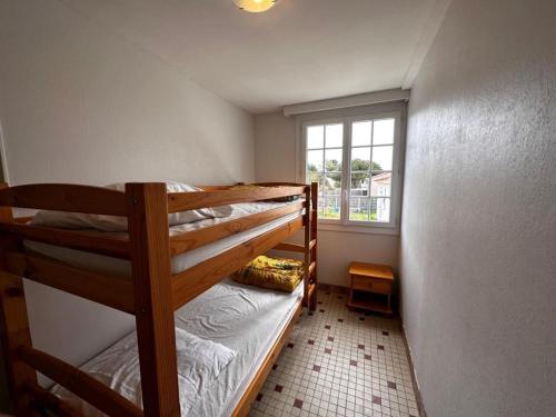 Cette petite chambre dispose de 2 lits superposés et d'une fenêtre. dans l'établissement Maison 2 chambres à 900m de la plage, terrasse & BBQ - FR-1-540-305, à Notre-Dame-de-Monts