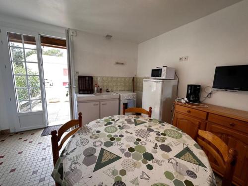 Il comprend une cuisine équipée d'une table et d'un réfrigérateur. dans l'établissement Maison 2 chambres à 900m de la plage, terrasse & BBQ - FR-1-540-305, à Notre-Dame-de-Monts
