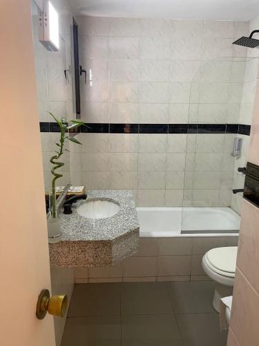 a bathroom with a sink and a tub and a toilet at Departamento 503 - Edificio VILAUT by INMOVE Temporarios in Córdoba