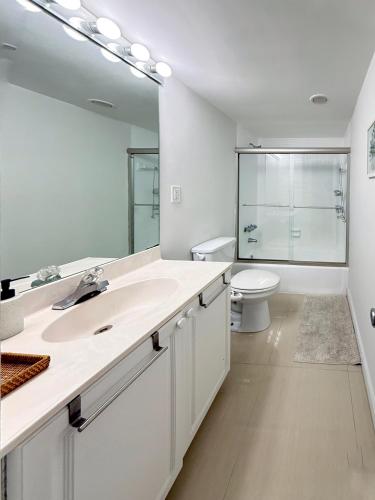 a bathroom with a sink and a toilet and a mirror at 1 SPRING PROMO - Sunny Isles Seaview Condo, Walk to Beach, Amazing Amenities in Sunny Isles Beach
