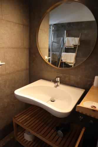 a bathroom with a white sink and a mirror at Aba da Serra - Turismo Rural in Abrigada