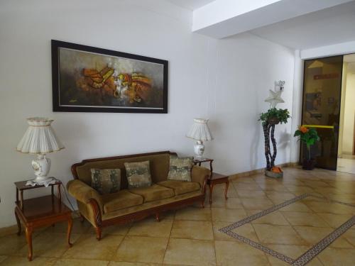 a living room with a couch and a painting on the wall at Hospedaje Dimar Inn in Lima