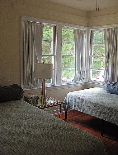 a bedroom with two beds and two windows at Mid-Century Modern meets Cajun Creole in Baton Rouge