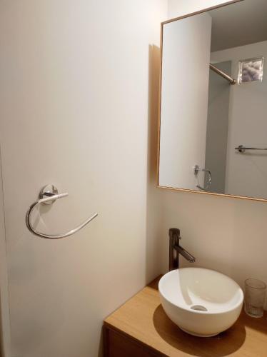 une salle de bain avec un lavabo blanc et un miroir dans l'établissement Studio en centre ville d'Uzès, à Uzès