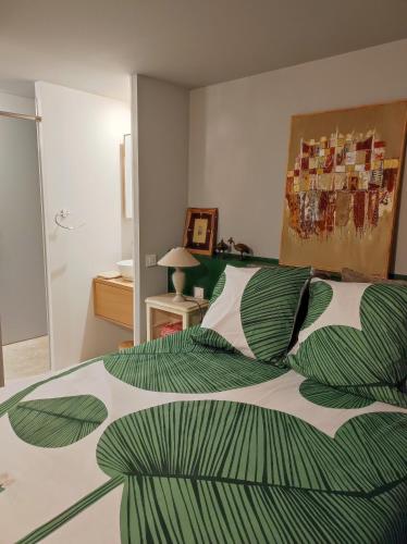 - une chambre avec un lit et une couette verte et blanche dans l'établissement Studio en centre ville d'Uzès, à Uzès