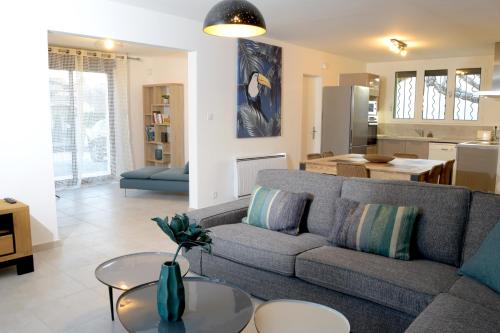 un salon avec un canapé et une cuisine dans l'établissement Gîte les Alouettes, à Uzès