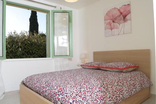 une chambre avec un lit et une fenêtre dans l'établissement Gîte les Alouettes, à Uzès