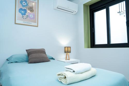 a blue bedroom with a bed with towels on it at Apartamento Molino y GARAJE in Ronda