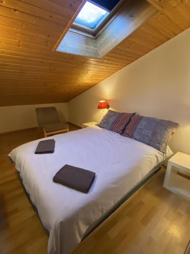 - une chambre avec un grand lit blanc et une lucarne dans l'établissement Apt Sakura - Le Grand Tetras, à Samoëns