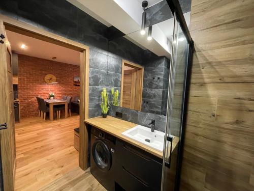 a bathroom with a sink and a washing machine at Koneser Warsaw by Better Place in Warsaw