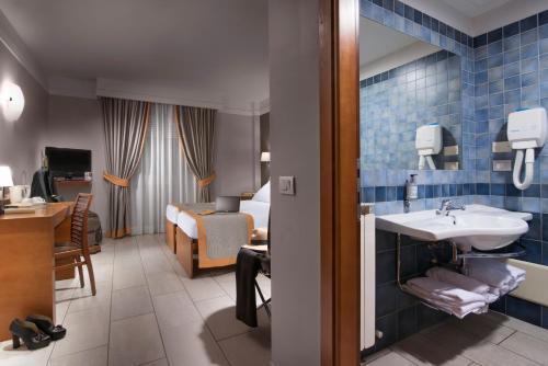 a hotel room with a sink and a bedroom at Hotel Il Viandante in Terranuova Bracciolini