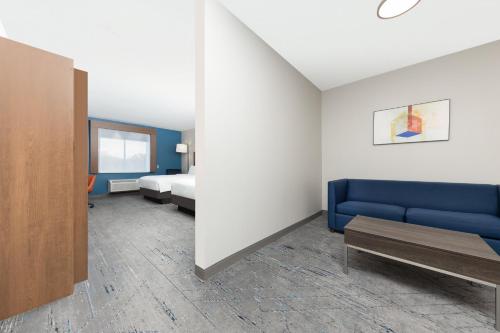 a room with a blue couch and a bed at Holiday Inn Express Hotel and Suites Athens by IHG in Athens