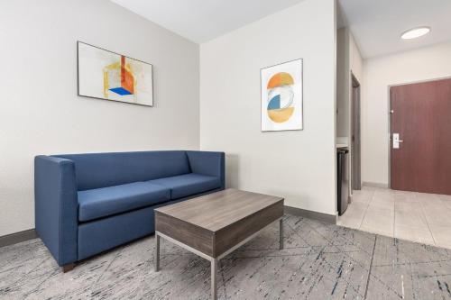 a living room with a blue couch and a table at Holiday Inn Express Hotel and Suites Athens by IHG in Athens
