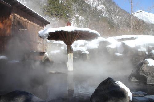a hot tub with snow on top of it at Shinzanso in Takayama