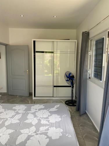 a bedroom with a bed and a glass closet at Tahiti - Bay Lodge in Taravao