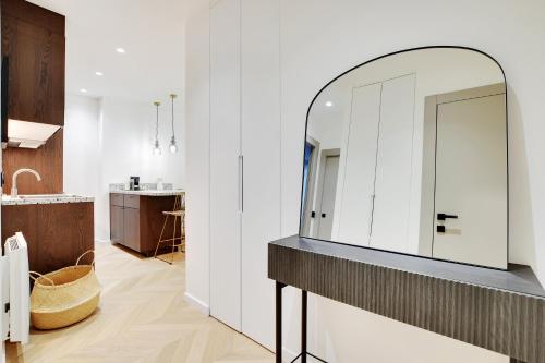 La salle de bains est pourvue d'un grand miroir sur un comptoir. dans l'établissement Appartement de luxe à Boulogne, à Boulogne-Billancourt