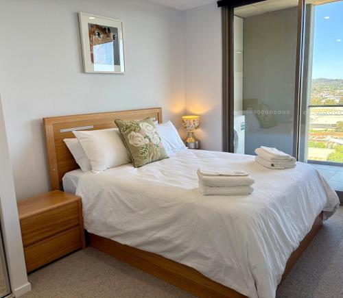 a bedroom with a bed with two towels on it at Stunning Apt central to Canberra & surrounds in Phillip