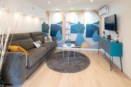 un salon avec un canapé et une télévision dans l'établissement LE COCON D'AZUR Jacuzzi - Terrasse- Vue mer- Wifi- Entièrement rénové, à Valbonne