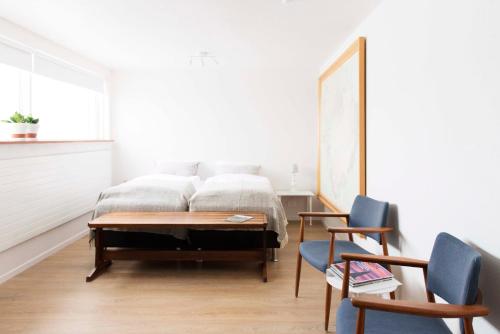 a bedroom with a bed with a table and two chairs at Natura Apartments in Laugar