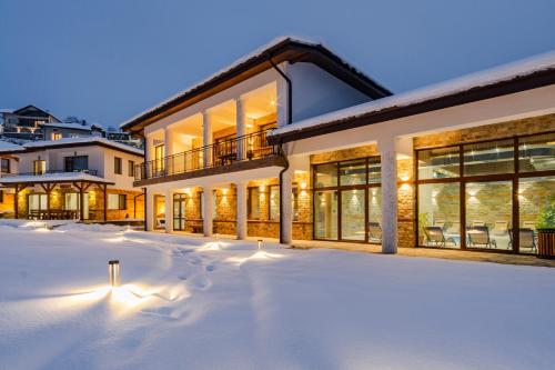 a house with snow in front of it at SPA Hotel Daffi in Smolyan