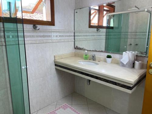 une salle de bain avec un lavabo et un miroir dans l'établissement Mansão Adalgisa Estúdio individual confortável de luxo, à Osasco