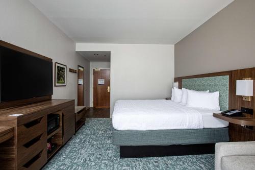 a hotel room with a bed and a flat screen tv at Hampton Inn & Suites Charleston-West Ashley in Charleston