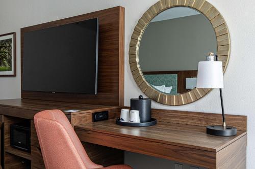 a room with a desk with a television and a mirror at Hampton Inn & Suites Charleston-West Ashley in Charleston