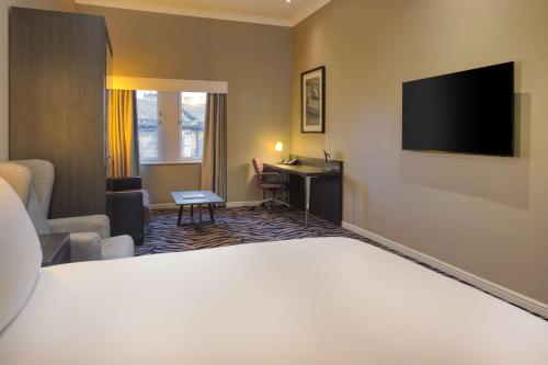 a hotel room with a bed and a desk at Doubletree by Hilton Edinburgh City Centre in Edinburgh