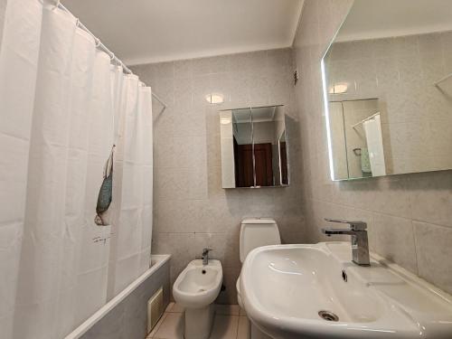 a white bathroom with a sink and a toilet at 4C Atlantico 1 - Casas & Papeis in Armação de Pêra