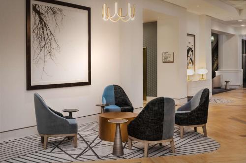 a waiting room with four chairs and a table at Hilton Lexington Downtown in Lexington