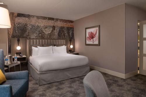 a hotel room with a large bed and a chair at Hilton Lexington Downtown in Lexington