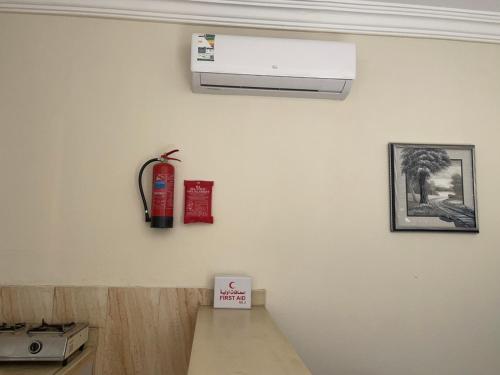 a kitchen with a fire extinguisher on a wall at شقق لين in Ḑubā
