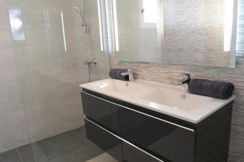 une salle de bain avec un lavabo et une douche dans l'établissement Gîte les Alouettes, à Uzès