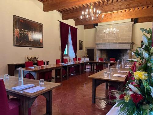 a large room with tables and chairs and a fireplace at Chateau des Ducs de Joueuse, BW Signature Collection in Couiza