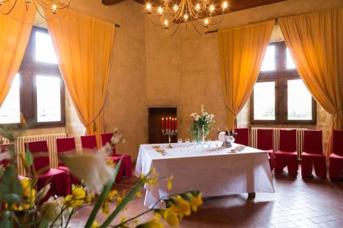 a dining room with a white table and red chairs at Chateau des Ducs de Joueuse, BW Signature Collection in Couiza