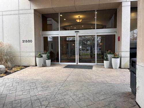 a glass door of a building with potted plants at Skyline Hotel Detroit Airport, SureStay Collection by Best Western in Romulus