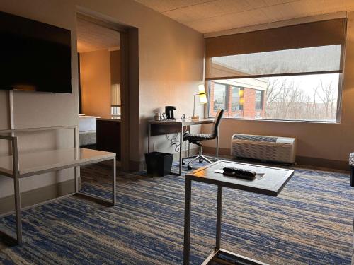 a hotel room with a bed and a desk with a computer at Skyline Hotel Detroit Airport, SureStay Collection by Best Western in Romulus