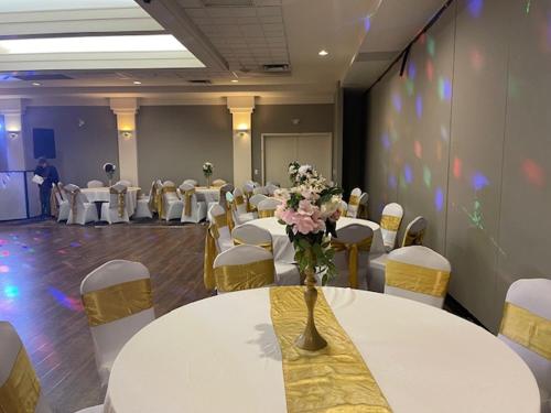 a room with tables and chairs and a vase with flowers at Royal Hotel Regina, Trademark Collection by Wyndham in Regina