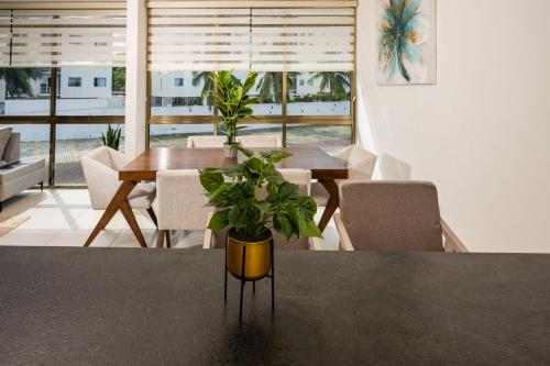 a dining room with a table with a potted plant at Magnifico con amenidades únicas in Cancún