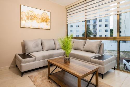 a living room with a couch and a table at Magnifico con amenidades únicas in Cancún