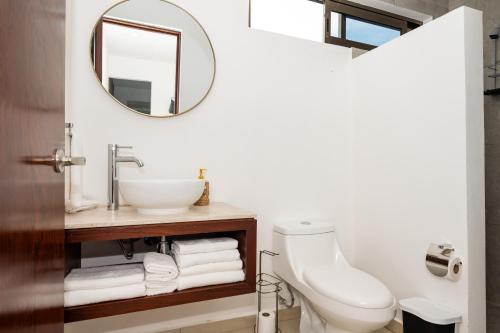 a bathroom with a sink and a toilet and a mirror at Magnifico con amenidades únicas in Cancún