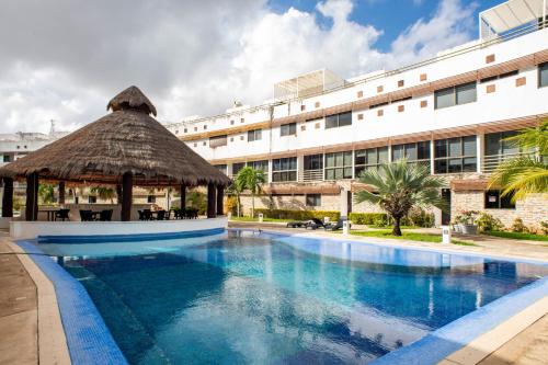 a swimming pool with a gazebo next to a building at Magnifico con amenidades únicas in Cancún