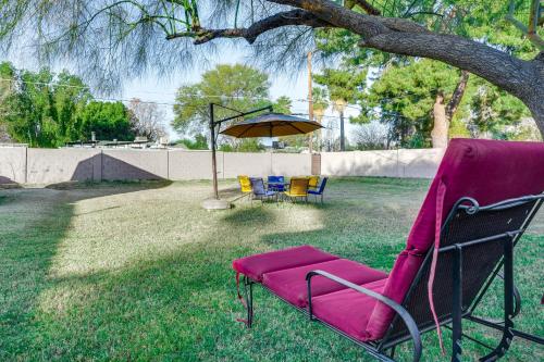 a pink chair sitting under a tree in a yard at Pet-Friendly Phoenix Home Breezeway and Fenced Yard in Phoenix
