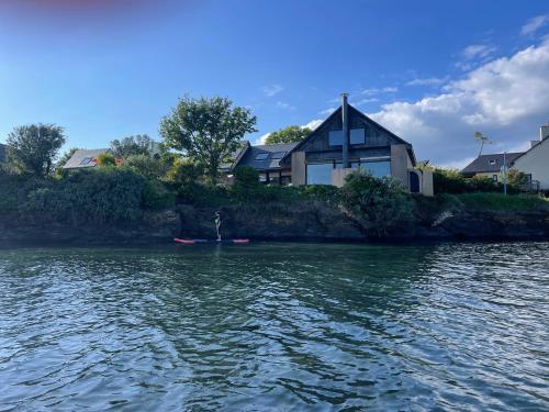 une maison au bord d'un plan d'eau dans l'établissement Rare Grande Villa Incroyable vue mer, à Roscanvel