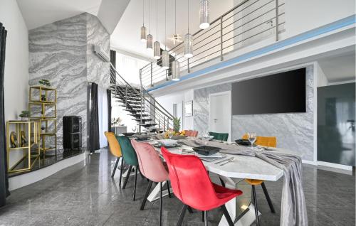 ein Esszimmer mit einem langen Tisch und bunten Stühlen in der Unterkunft 2 Bedroom Amazing Home In Bjelovar in Bjelovar