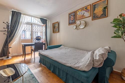 une chambre avec un lit, une table et un bureau dans l'établissement Appartement 2 étages Paris - Métro 9 Grands Boulevards - Folies Bergères, à Paris
