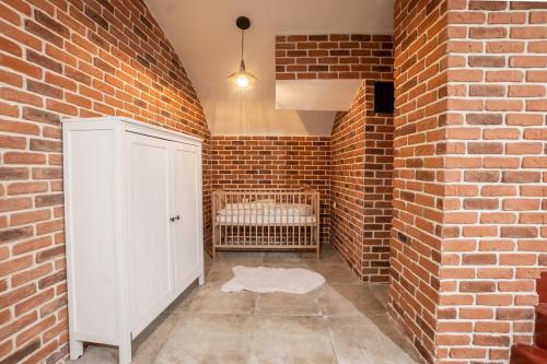 Cette chambre est dotée d'un mur en briques et d'une armoire blanche. dans l'établissement Appartement 2 étages Paris - Métro 9 Grands Boulevards - Folies Bergères, à Paris