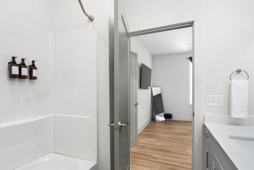 a white bathroom with a shower and a sink at 1B 1B Round Rock Pool, Sauna, On-Site Coffee Shop in Pflugerville